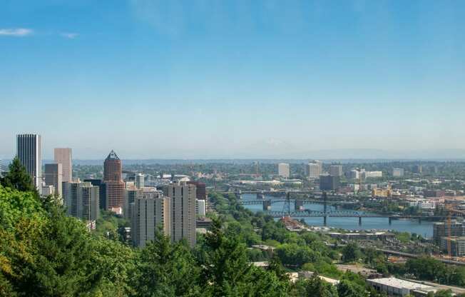 a view of the city with a river and mountains in the background