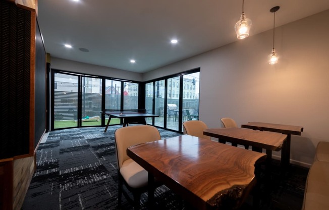 a conference room with a wooden table and chairs and large windows at 310 at Nulu Apartments-Student, Louisville, KY 40202