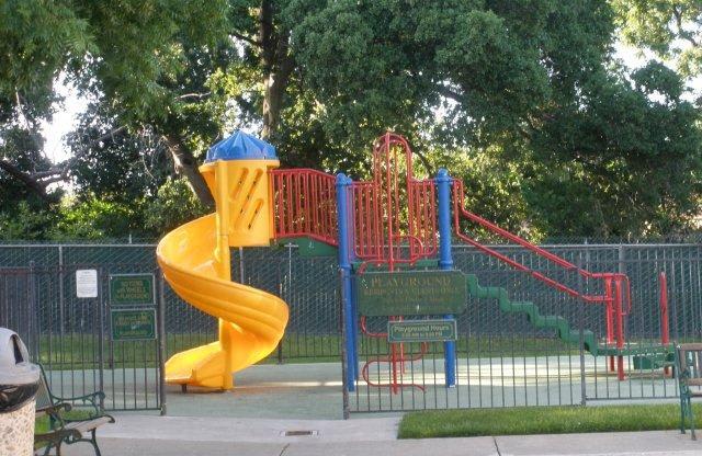 a childrens playground with a large yellow slide