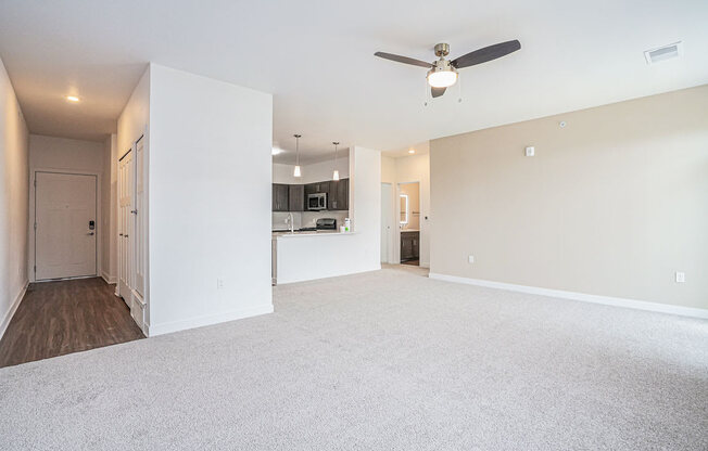 an empty living room with a ceiling fan at Meadowbrooke Apartment Homes, Michigan