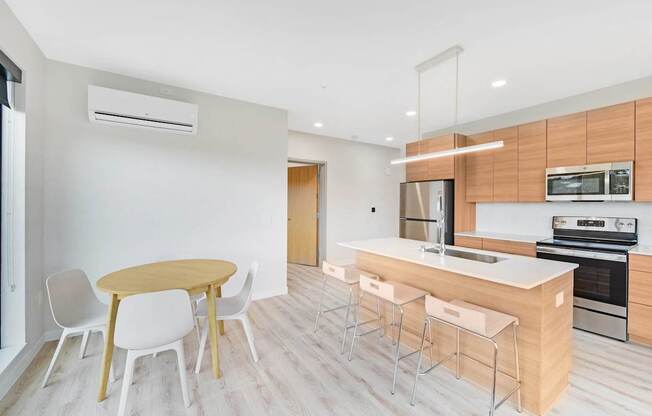 A modern kitchen with a wooden table and white chairs.