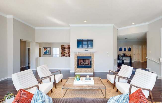 a living room with white furniture and a fireplace