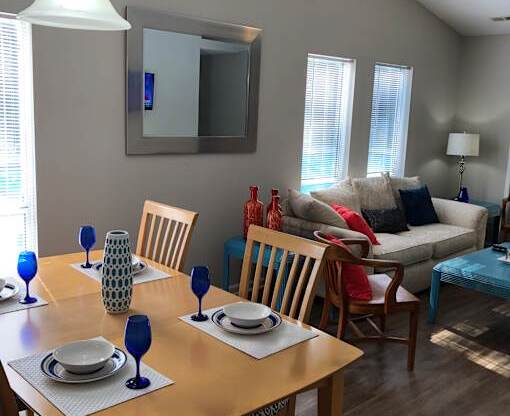 A dining room with a wooden table set for two.