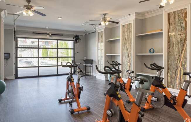 an indoor cardio room with exercise bikes and a window at Arlo Luxury homes Apartments, Little Rock, AR,72210