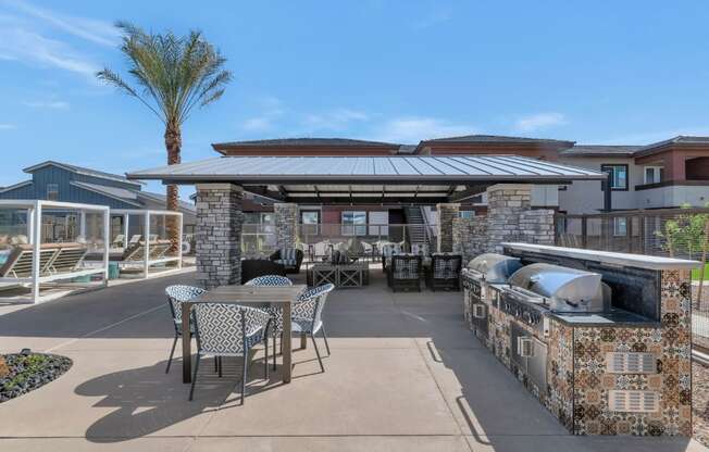 A patio with a table and chairs is surrounded by a stone wall.