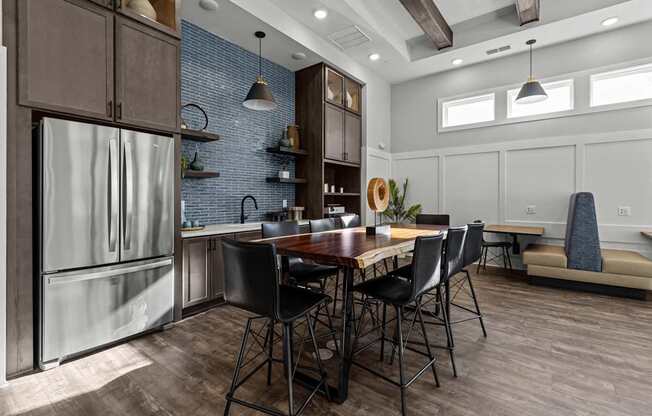 A kitchen with a table and chairs in the foreground and a refrigerator on the left.
