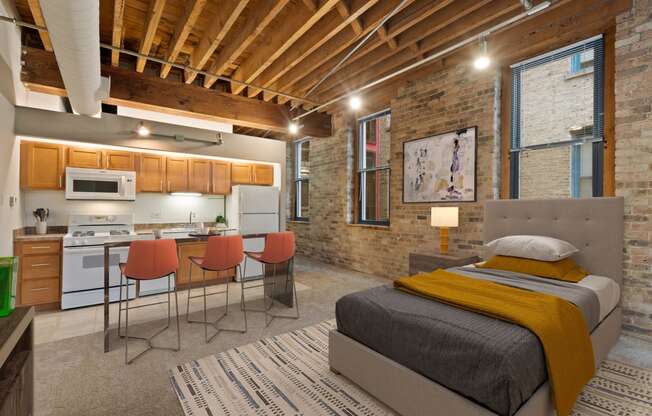 a bedroom with a bed and a kitchen in a loft