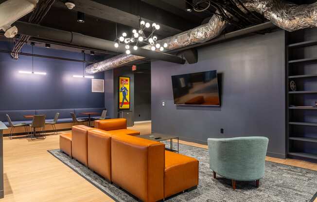 a lobby with couches and chairs and a tv