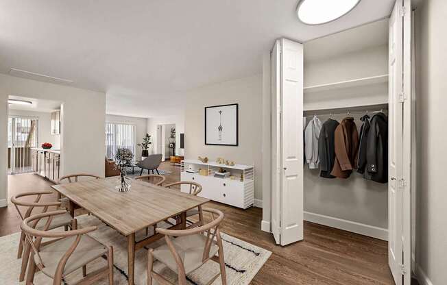 A room with a table and chairs and a wardrobe.