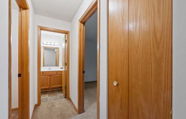 the entrance to a bathroom and a hallway with a door to a bedroom