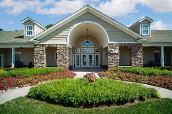A building with a stone archway entrance and a landscaped front yard.