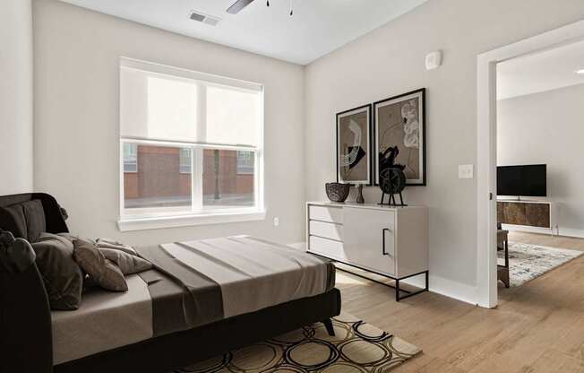 A bedroom with a bed, a dresser, and a window.