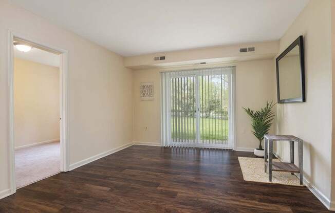 an empty living room with a sliding glass door and a window