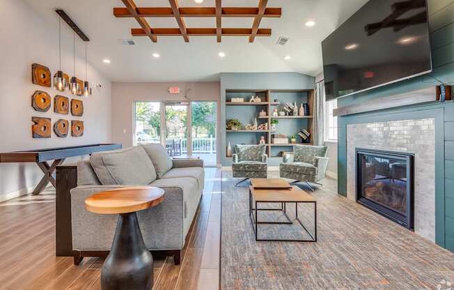 A modern living room with a grey couch, a wooden coffee table, and a fireplace.
