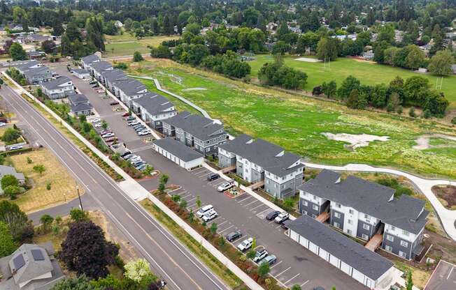 A large apartment complex with a parking lot in front.