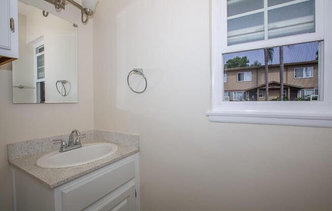 a white sink sitting under a window