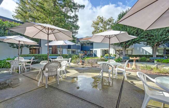 a patio with tables and chairs and umbrellas