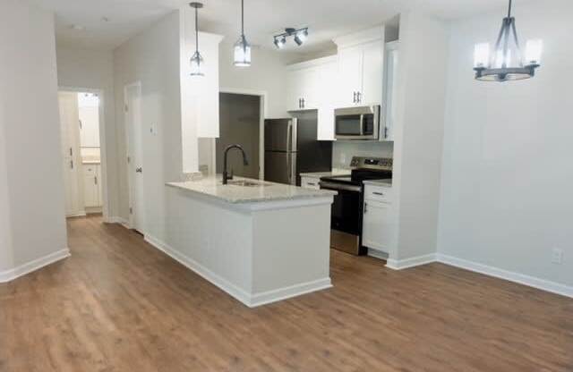 A kitchen with a white island and wooden floors.