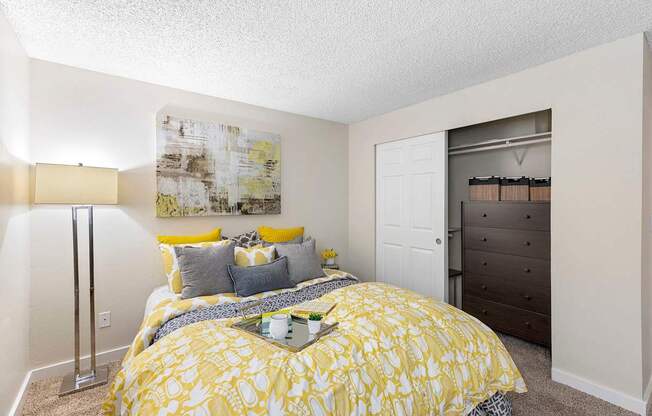 A bedroom with a yellow bedspread and a white door.