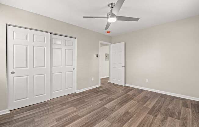 a bedroom with hardwood flooring and a ceiling fan