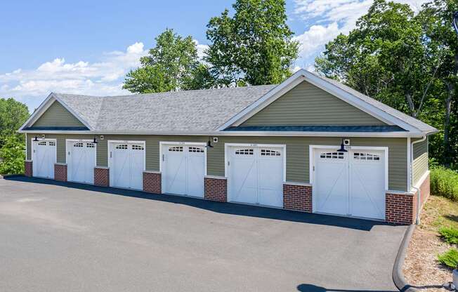 A building with a grey roof and white garage doors.