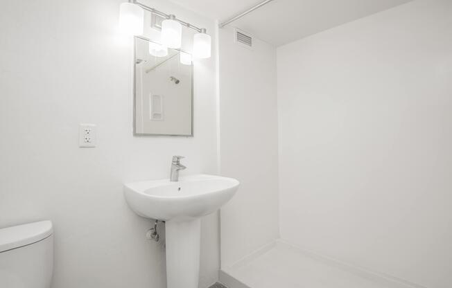 a white sink sitting under a mirror