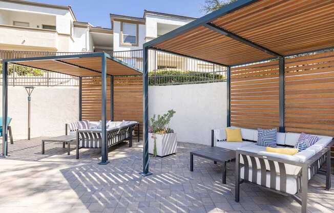 A patio with a striped couch and a table with a potted plant on it.