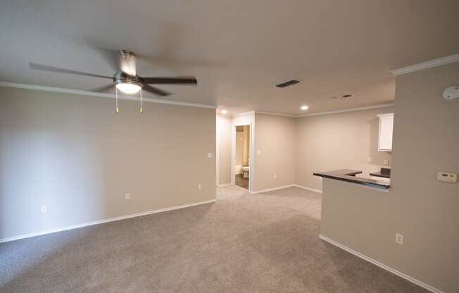 View from front entry of upstairs Tuscany - Chablis with carpet flooring, ceiling fan, view of kitchen bar, and view into bathroom