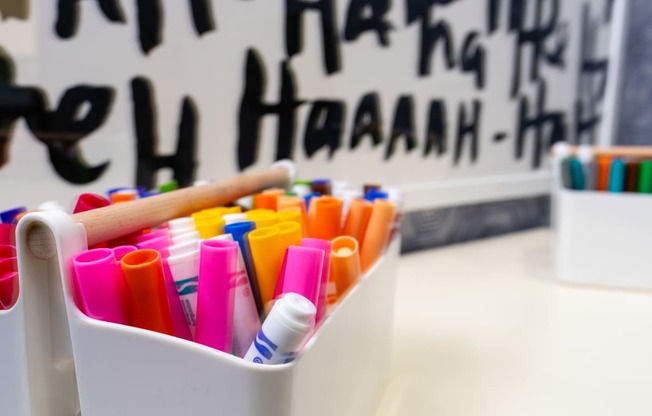 a basket of colored pencils in front of a black and white wall