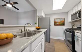 A kitchen with a bowl of oranges on the counter.