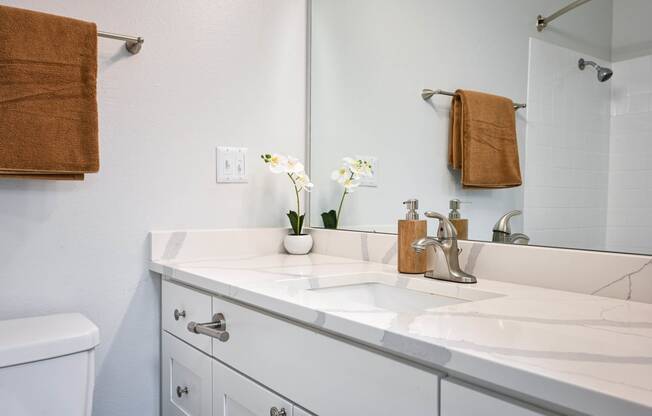 a white bathroom with a sink and a mirror