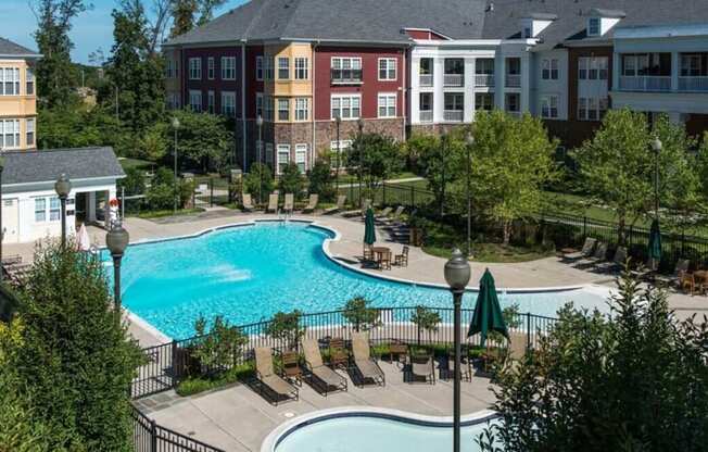 an aerial view of a swimming pool in front of an apartment building