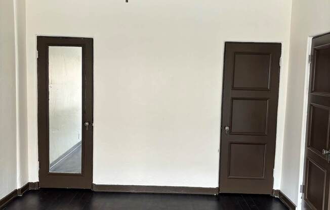 an empty living room with wooden floors and a ceiling fan