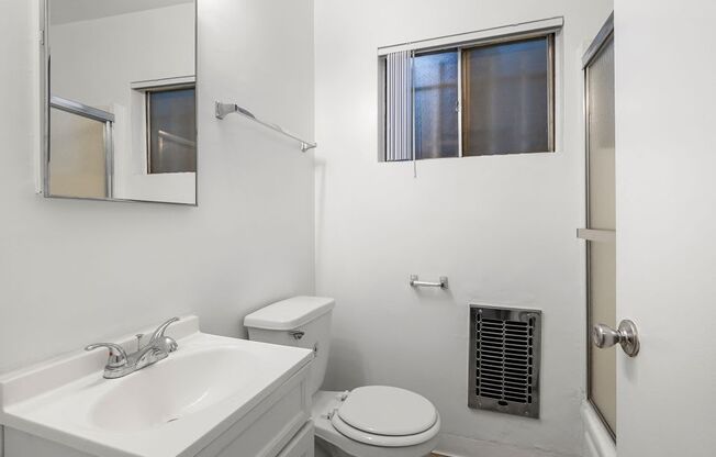 a bathroom with a sink toilet and mirror