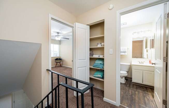 a stairway leading to a bathroom and a hallway with a closet