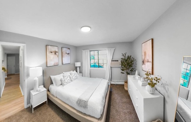 a white bedroom with a large bed and a mirror