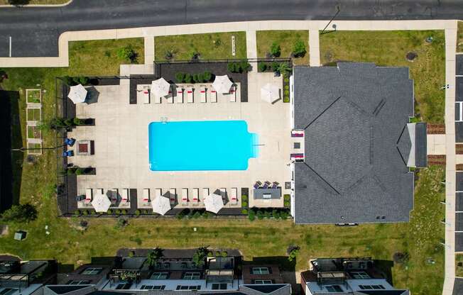 A swimming pool surrounded by lounge chairs and umbrellas.