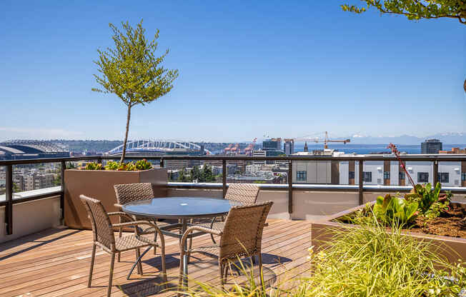 a balcony with a table and chairs and a view of the city