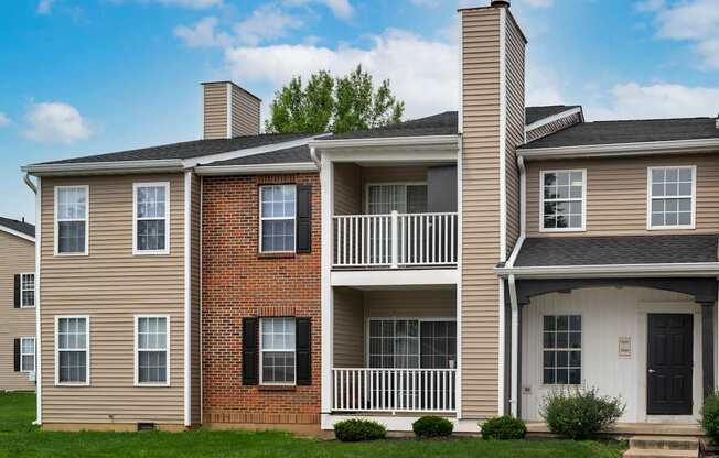 A two-story house with a balcony and a black door.