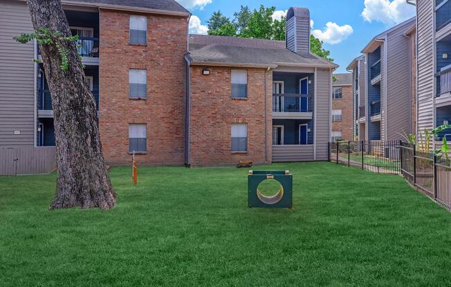 a large brick building with green grass in front of a house