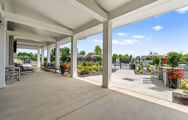 A covered patio area with a white ceiling and wooden floor.