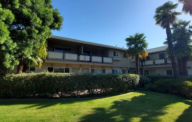 an apartment building with palm trees in front of it