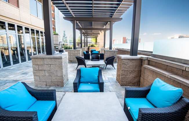 an outdoor lounge area with blue couches and chairs
