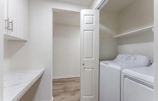 A white door is open to a laundry room.