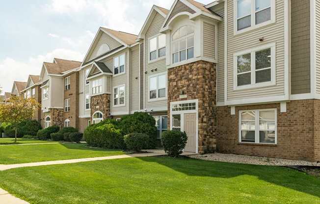 A row of houses with a green lawn in front
