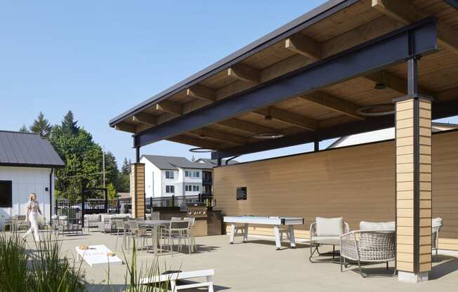 a patio with tables and chairs and a ping pong table