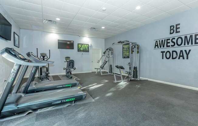 A gym with treadmills and a wall that says "Be Awesome Today".