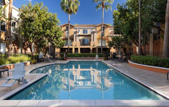 A pool with a reflection of a building in the water.