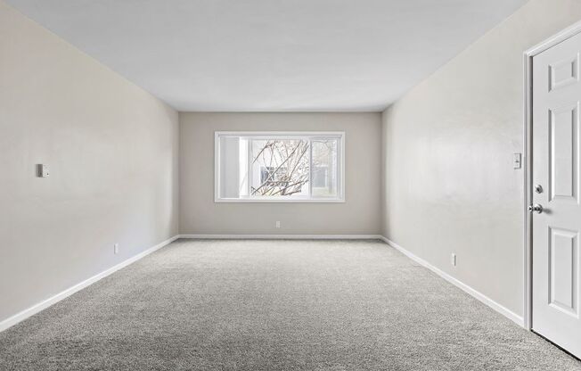 an empty room with a window and a door