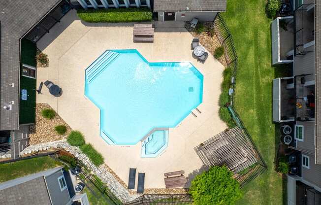 A small swimming pool surrounded by a fence and a small garden.